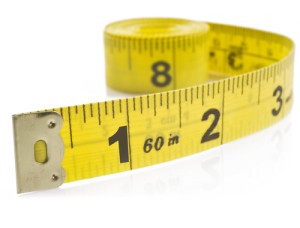 Yellow tape measure on rolled up on white background