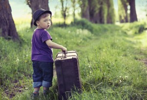 Little cute man leaving home with huge luggage